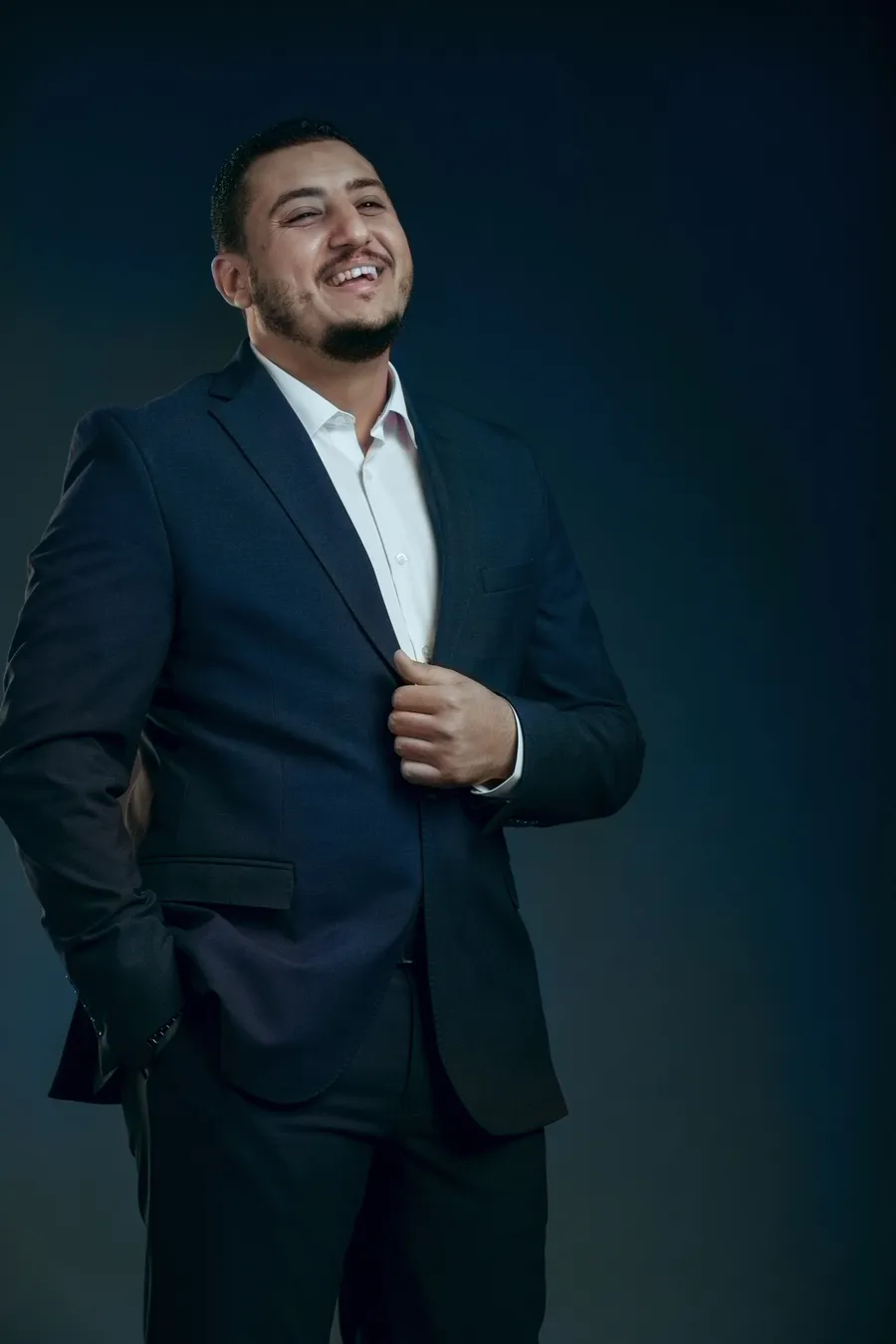 Ahmed Adel Serour smiling in a navy suit